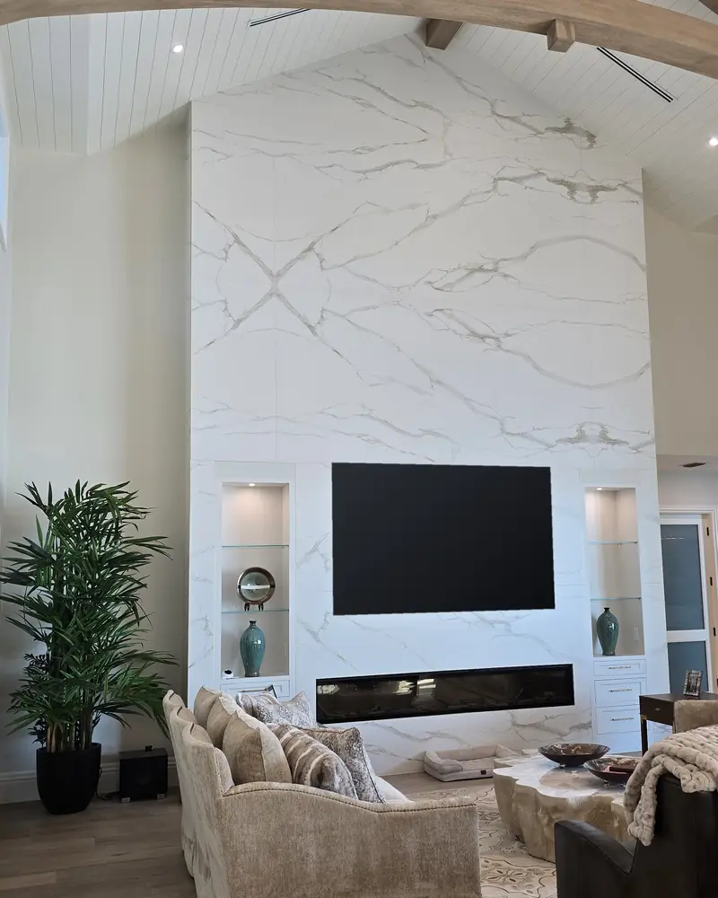 The finished great room: the porcelain fireplace wall with the TV, lit shelves and furniture