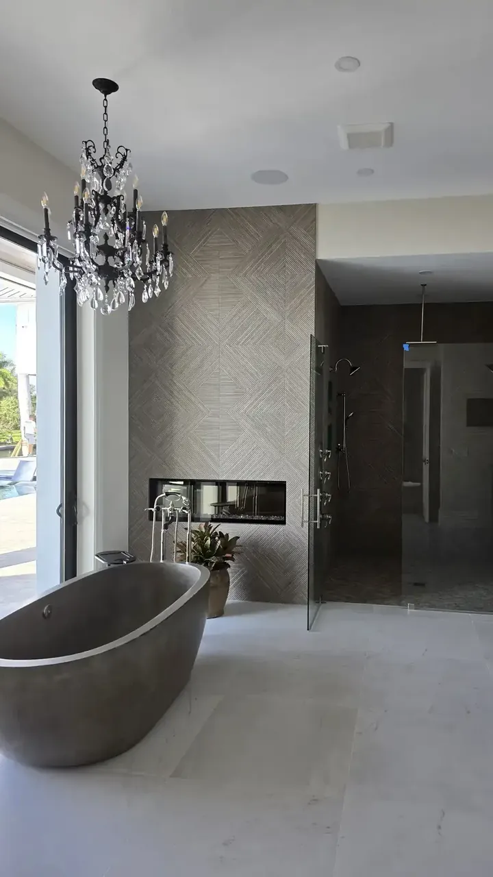 Master bathroom with a freestanding stone tub, chandelier, fireplace and walk-in shower