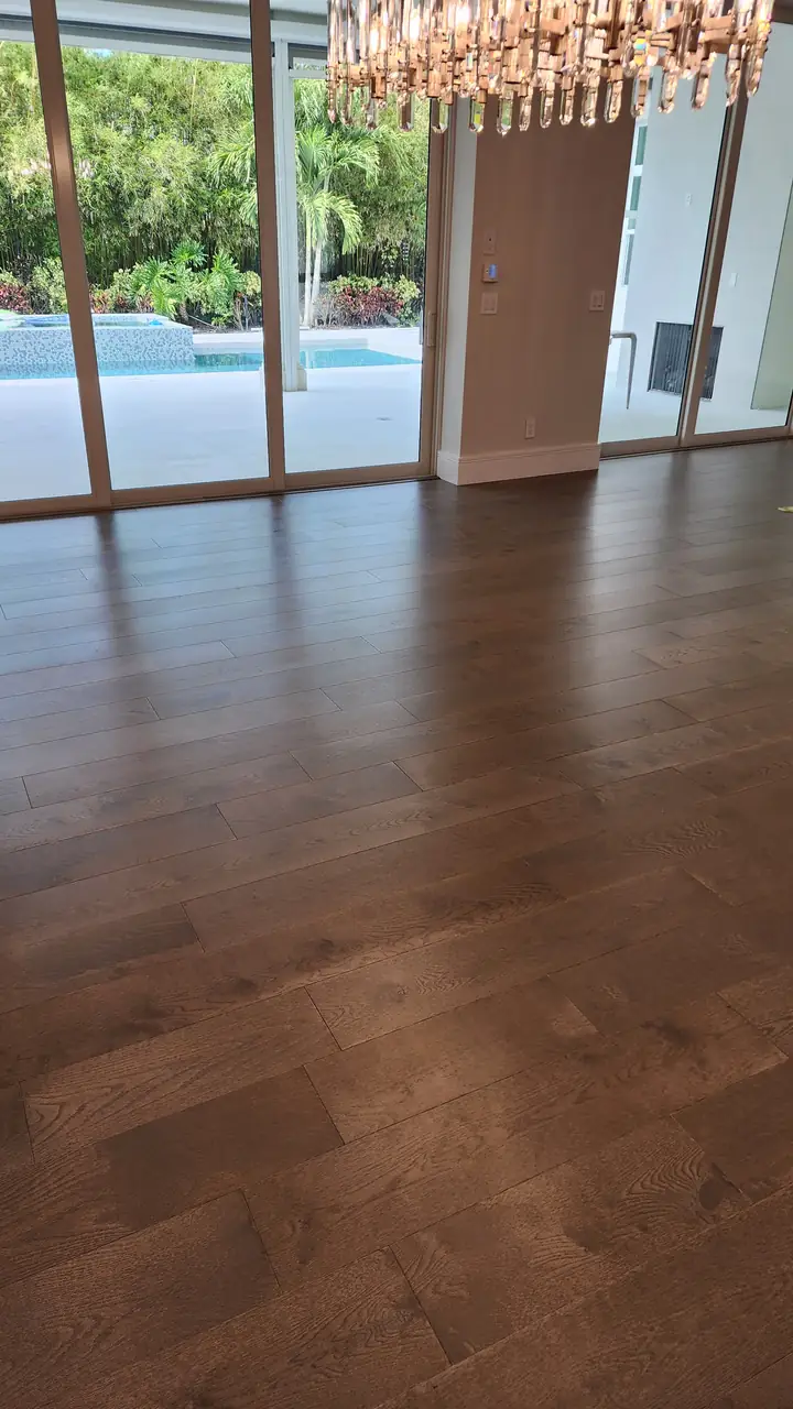 Wood floor in a living room with sliding doors to the pool